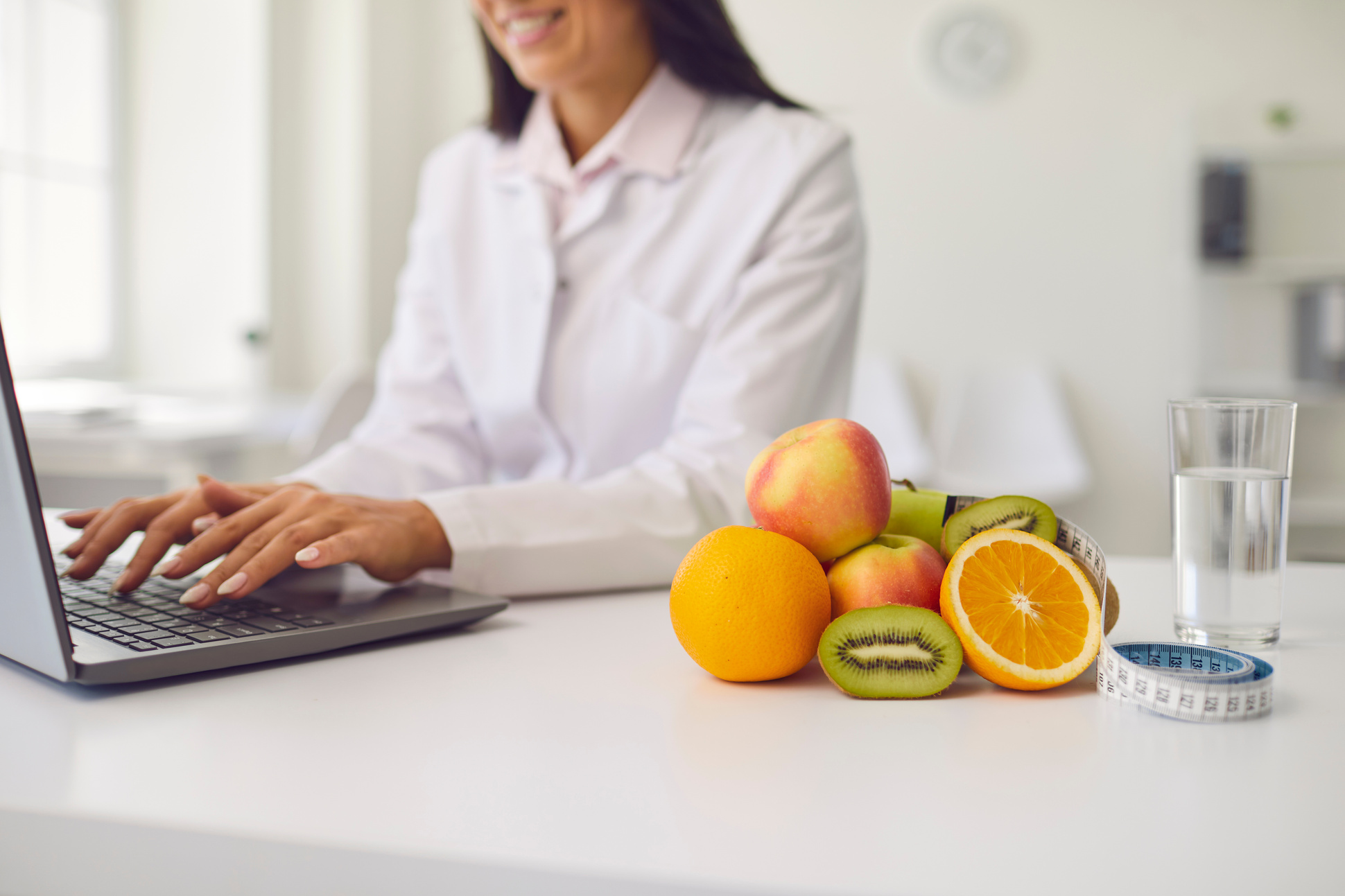 Fruit, a Glass of Water and a Tape Measure Lie on the Table against the Background of a Nutritionist